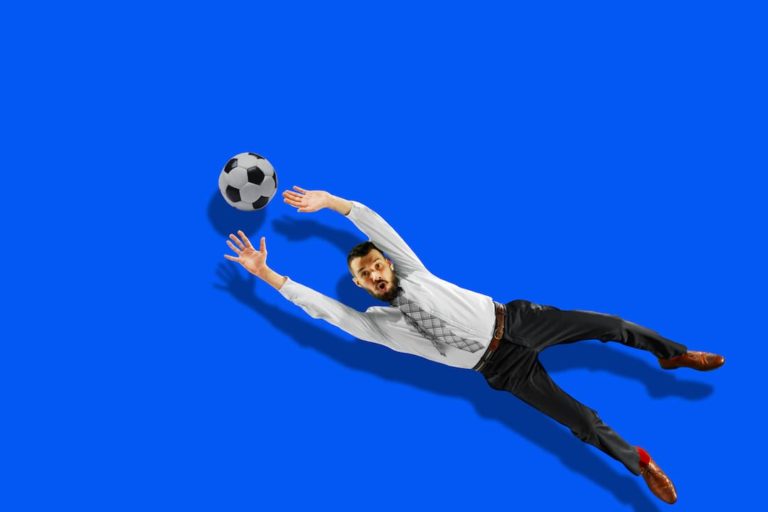 Office Worker Diving For A Football In A Suit